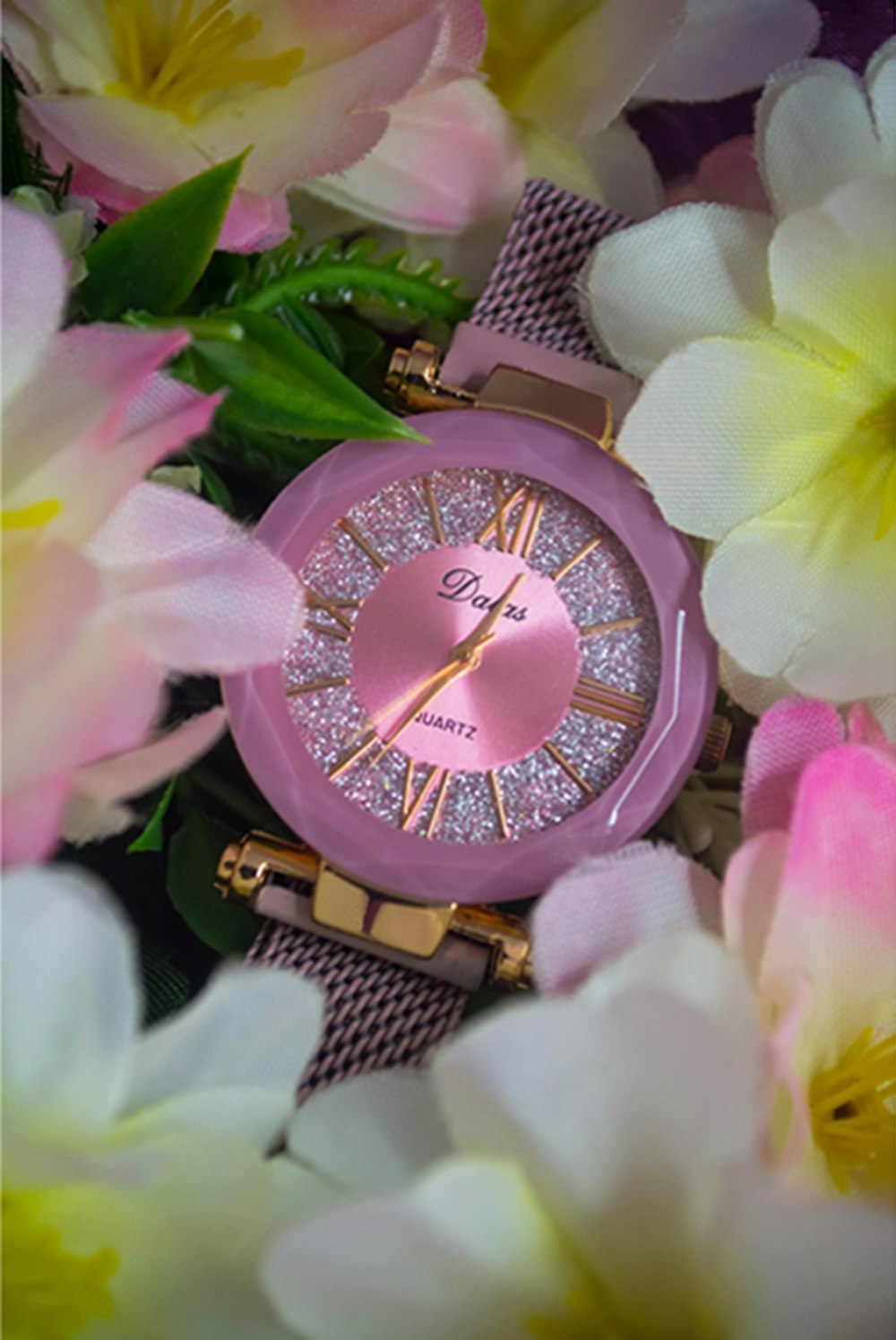 um relógio rosa cercado por flores rosas e brancas