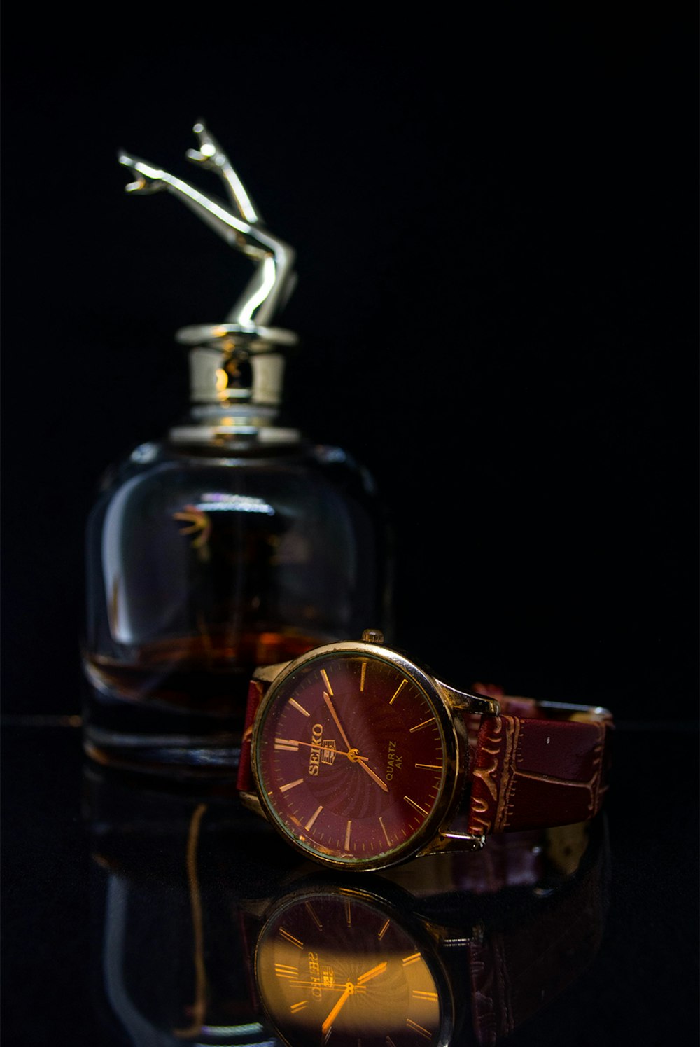 a watch sitting on top of a table next to a bottle