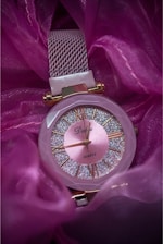 a close up of a watch on a purple cloth