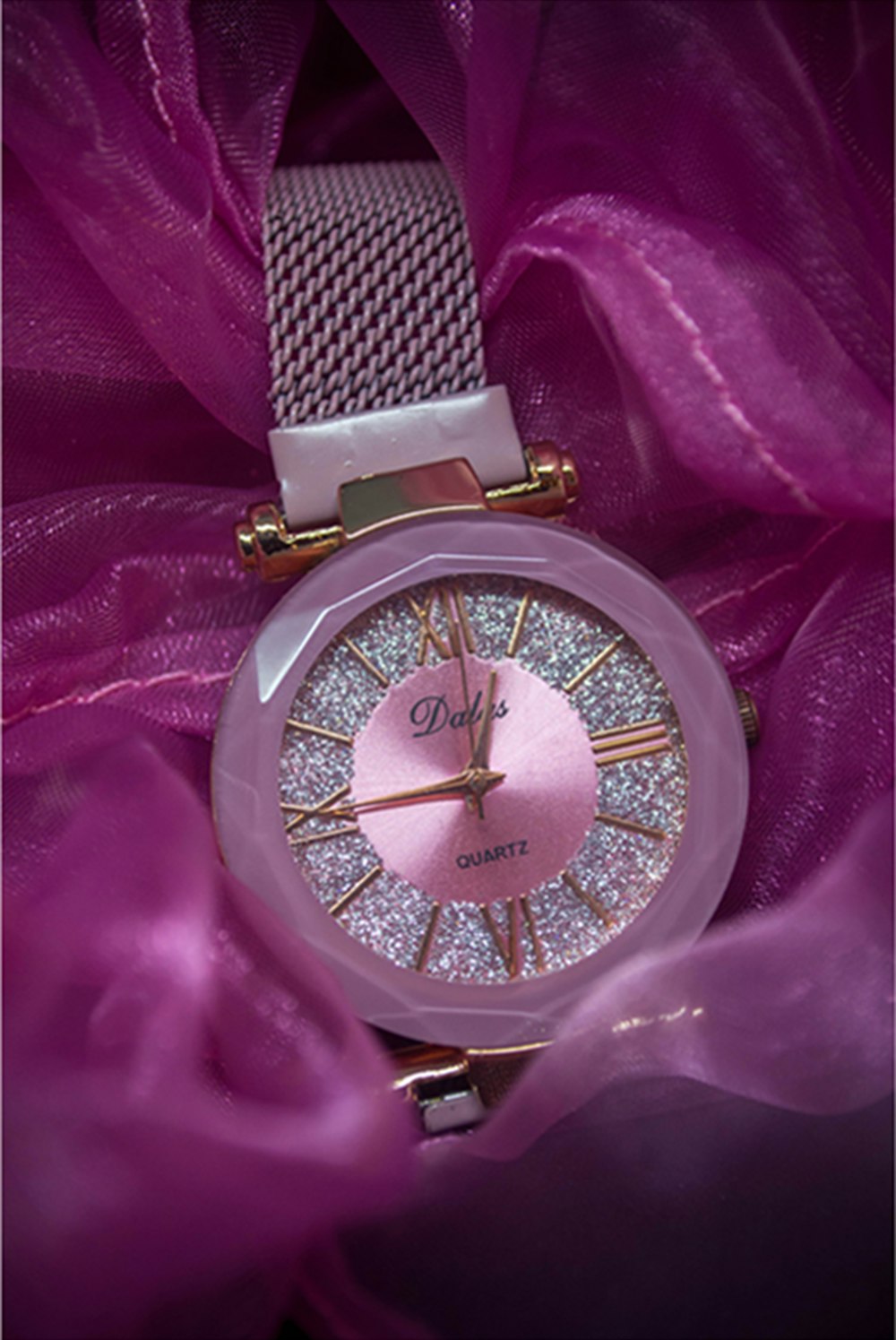 a close up of a watch on a purple cloth