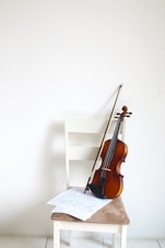 a violin sitting on top of a white chair