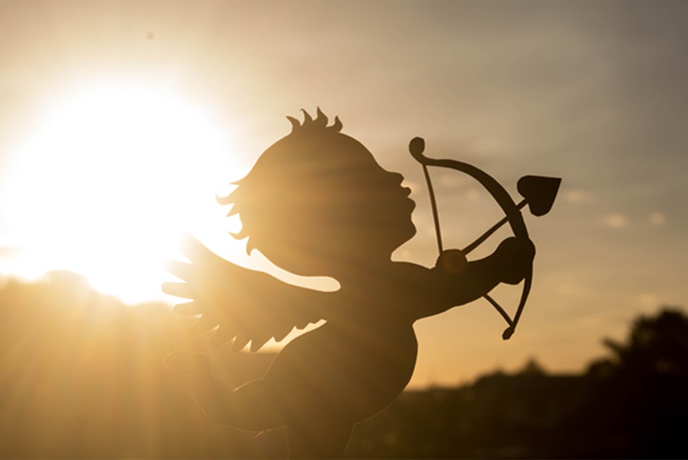 a silhouette of a cupid holding a bow and arrow