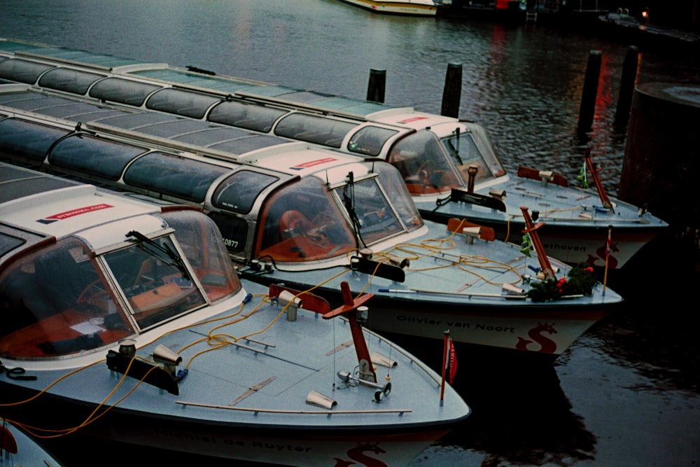 a row of boats sitting next to each other on a body of water
