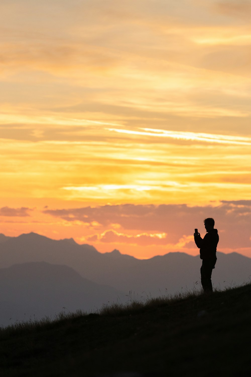 a person standing on top of a grass covered hill