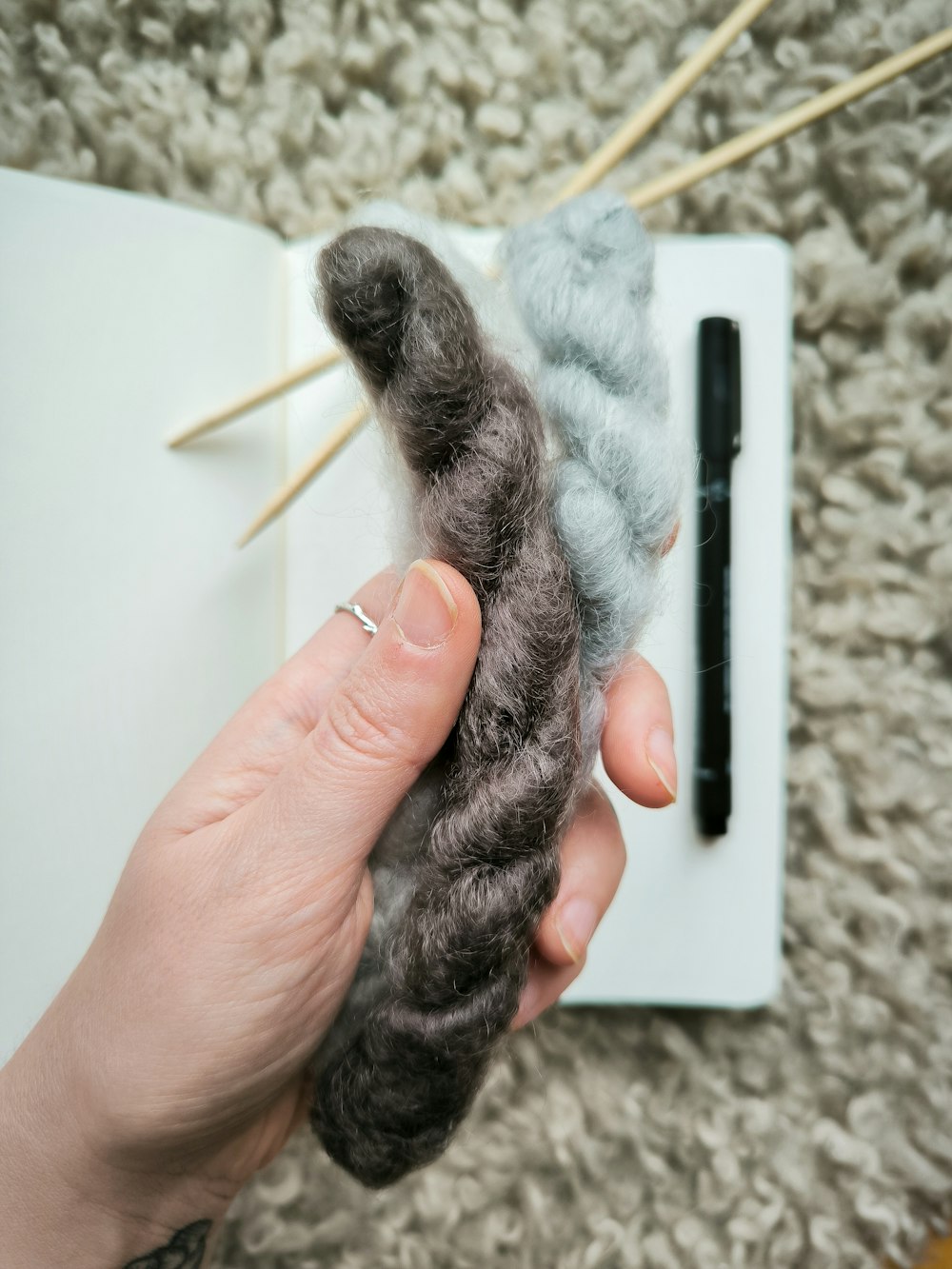 a person holding a piece of yarn in their hand