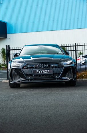 a blue car parked in front of a building