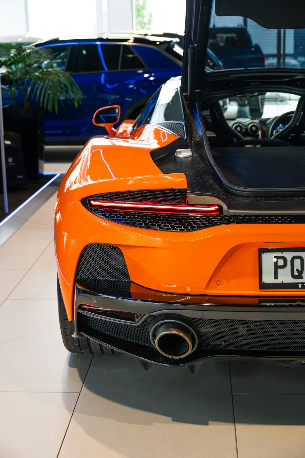 an orange sports car parked in a showroom