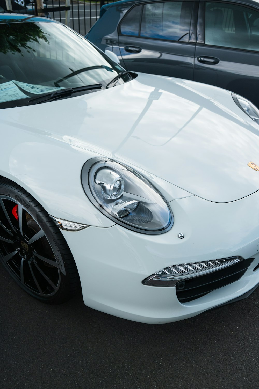 a white sports car parked in a parking lot