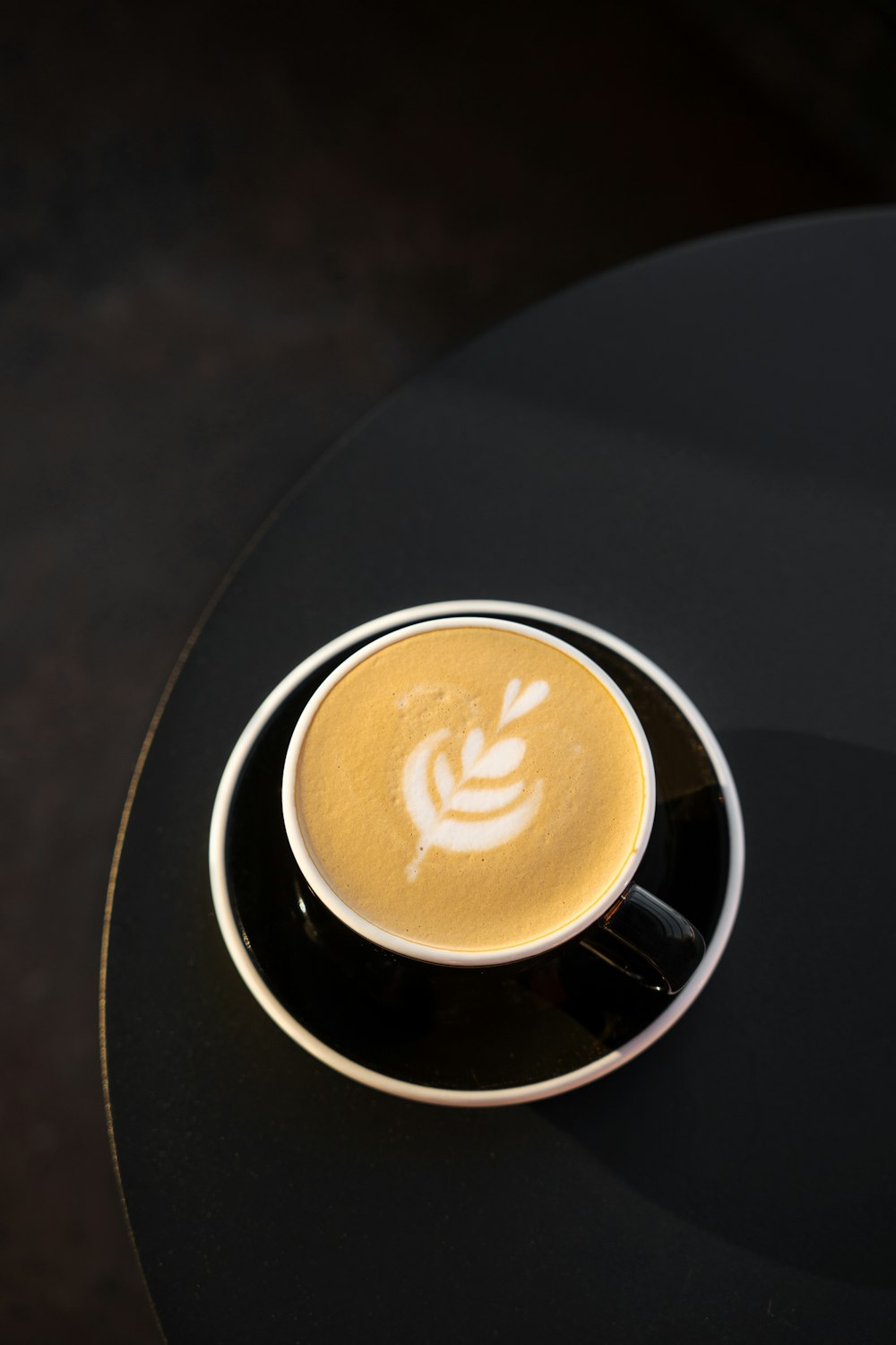 a cappuccino sitting on top of a black table