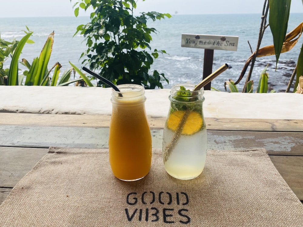 a couple of jars filled with drinks sitting on top of a table