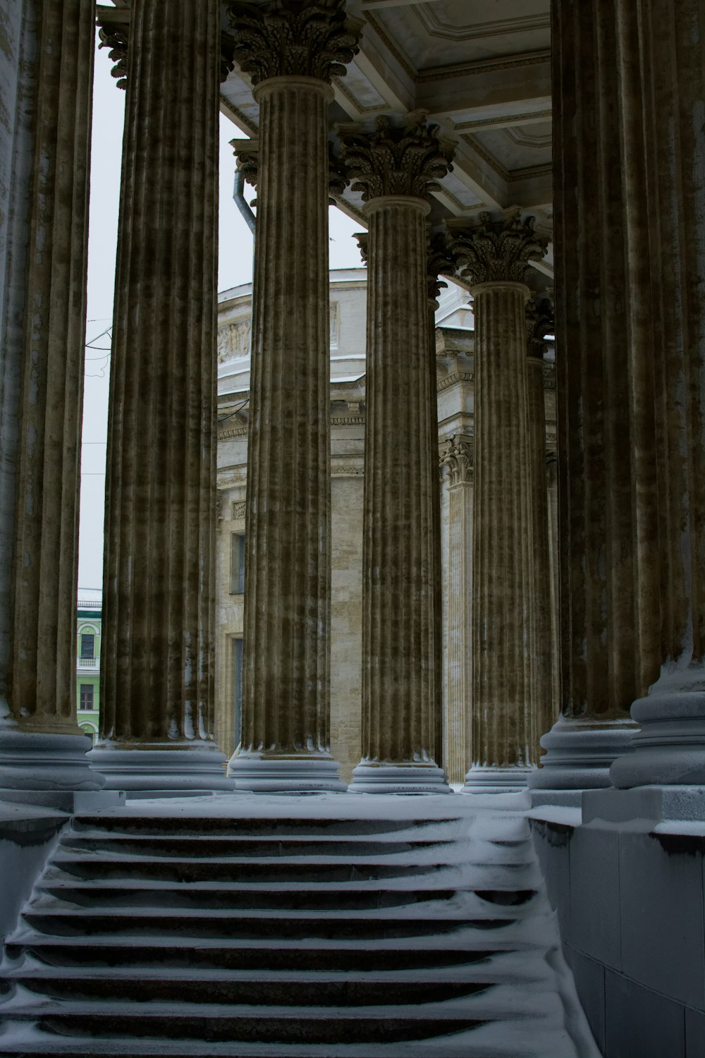 Un gran edificio con columnas y escalones cubiertos de nieve