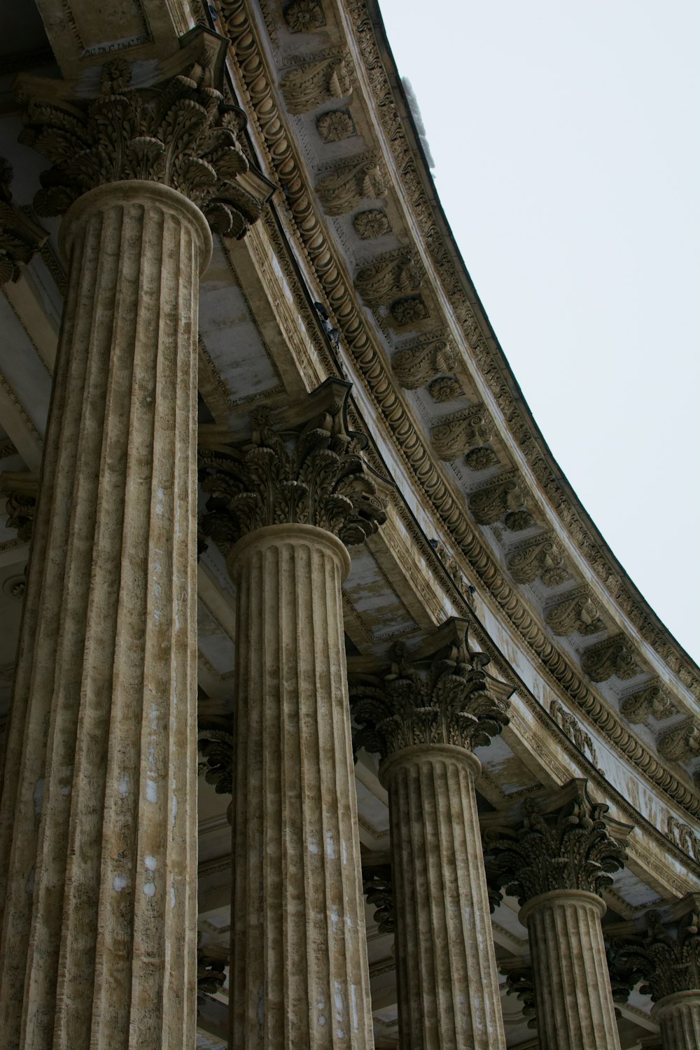 a building with many pillars and a clock on the side of it