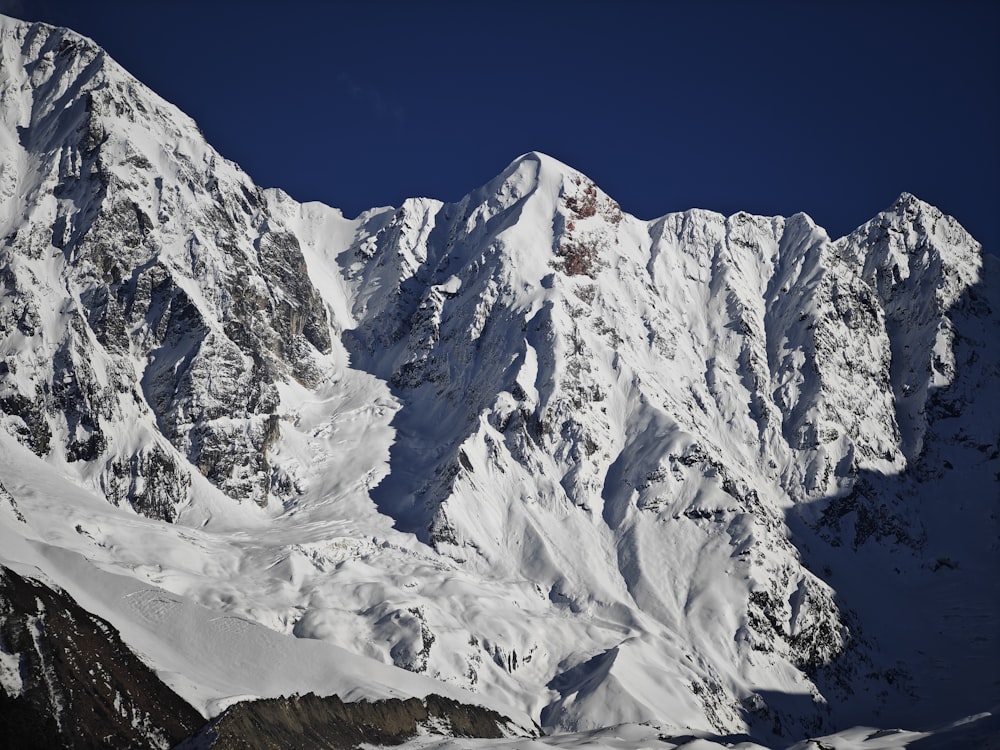 una gran montaña cubierta de nieve bajo un cielo azul