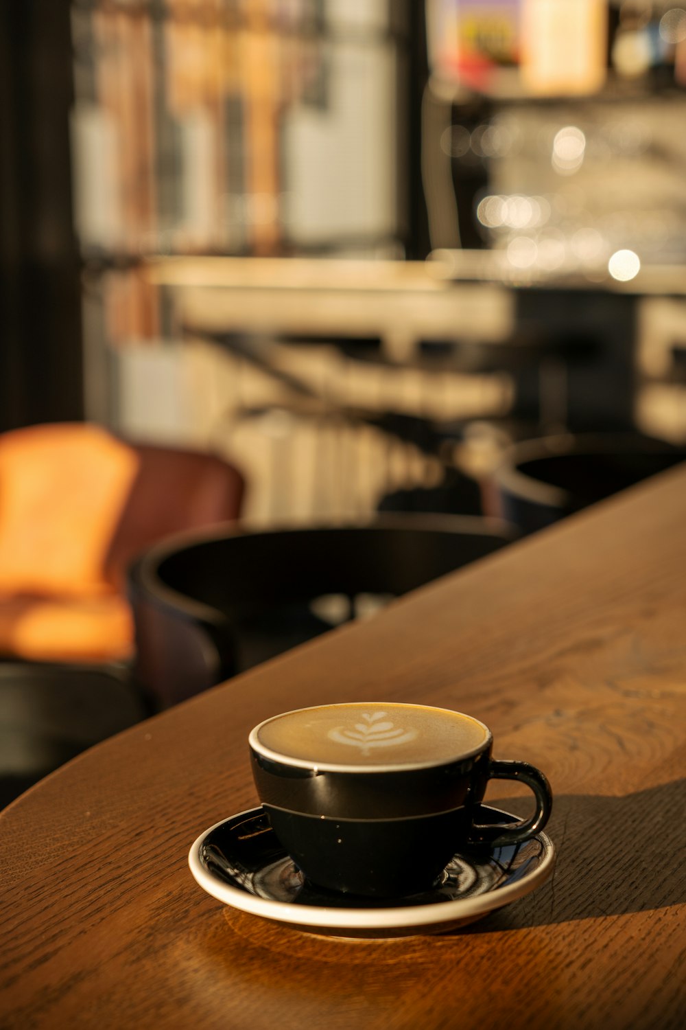 a cup of coffee sitting on top of a wooden table