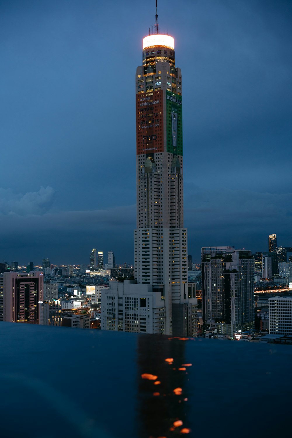 a very tall building towering over a city at night