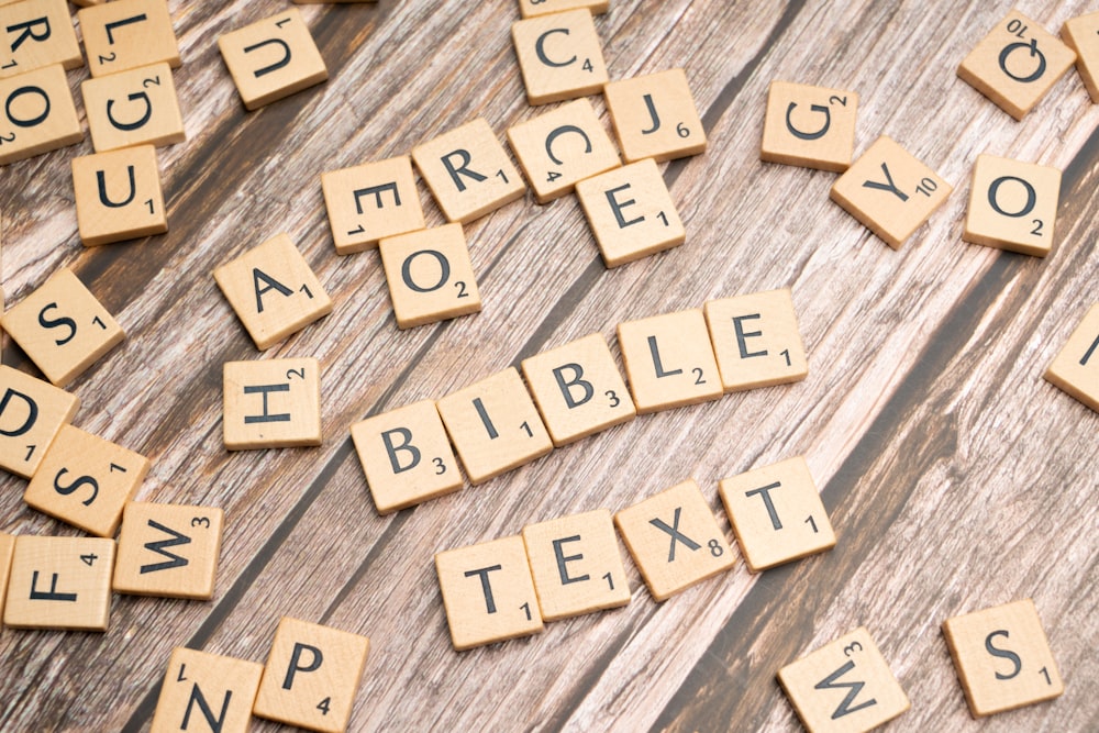 scrabble tiles spelling the word bible on a wooden table