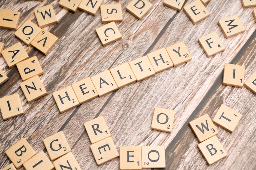 scrabble tiles spelling out the word healthy on a wooden surface