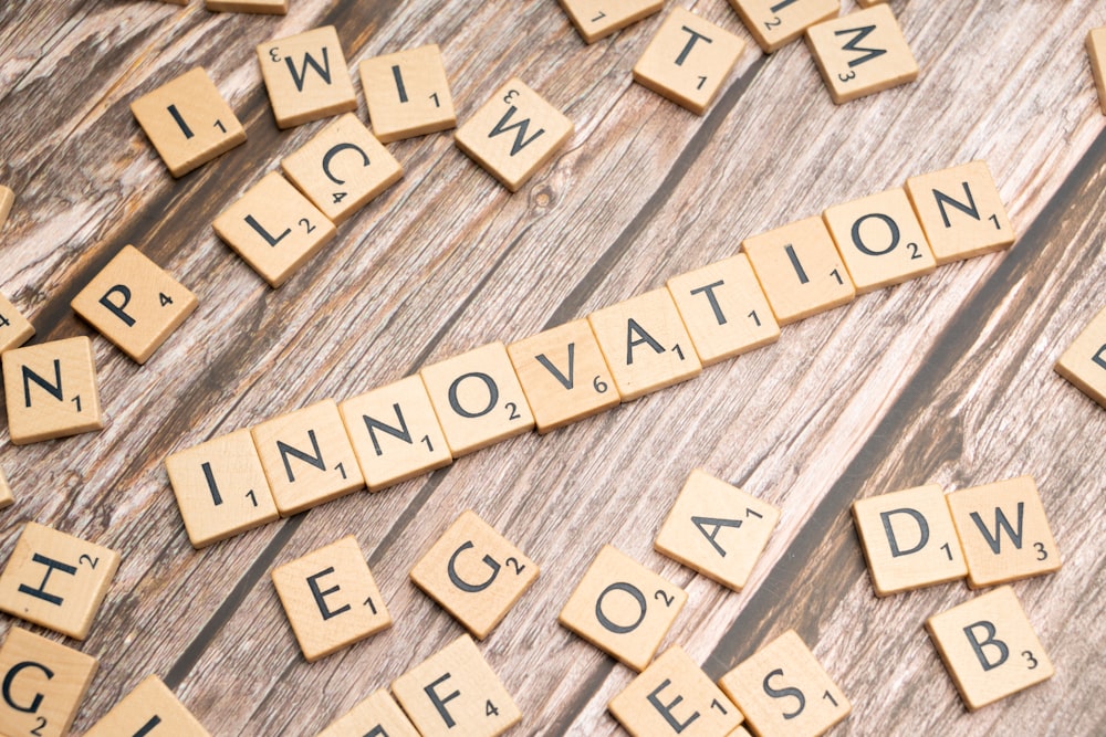 scrabble tiles spelling the word innovation on a wooden surface