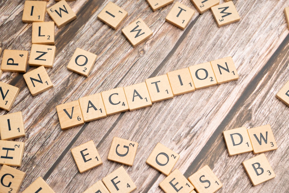 scrabble tiles spelling vacation on a wooden surface