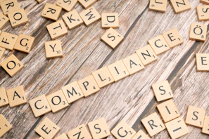 The word compliance spelled out with wooden letter tiles on a rustic table
