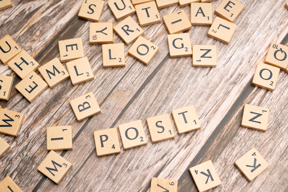 a close up of scrabble letters on a wooden surface