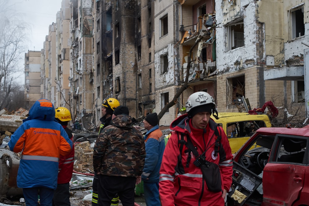 a group of people standing around a destroyed building