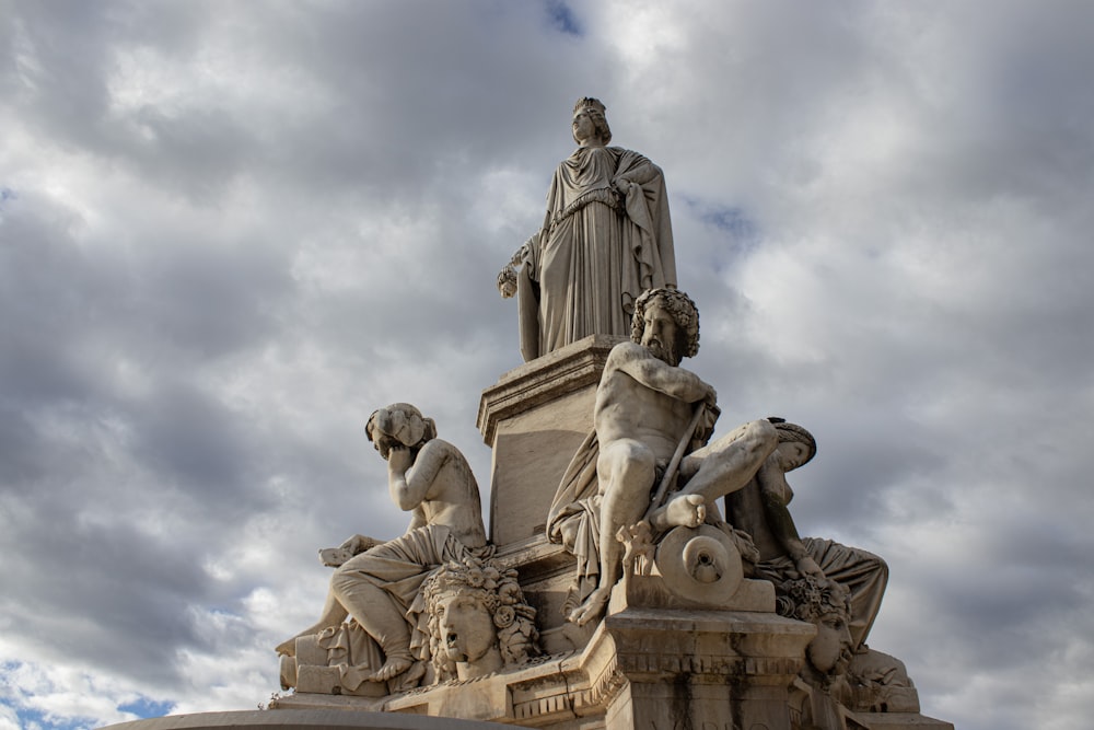 une statue d’un homme assis au sommet d’une statue