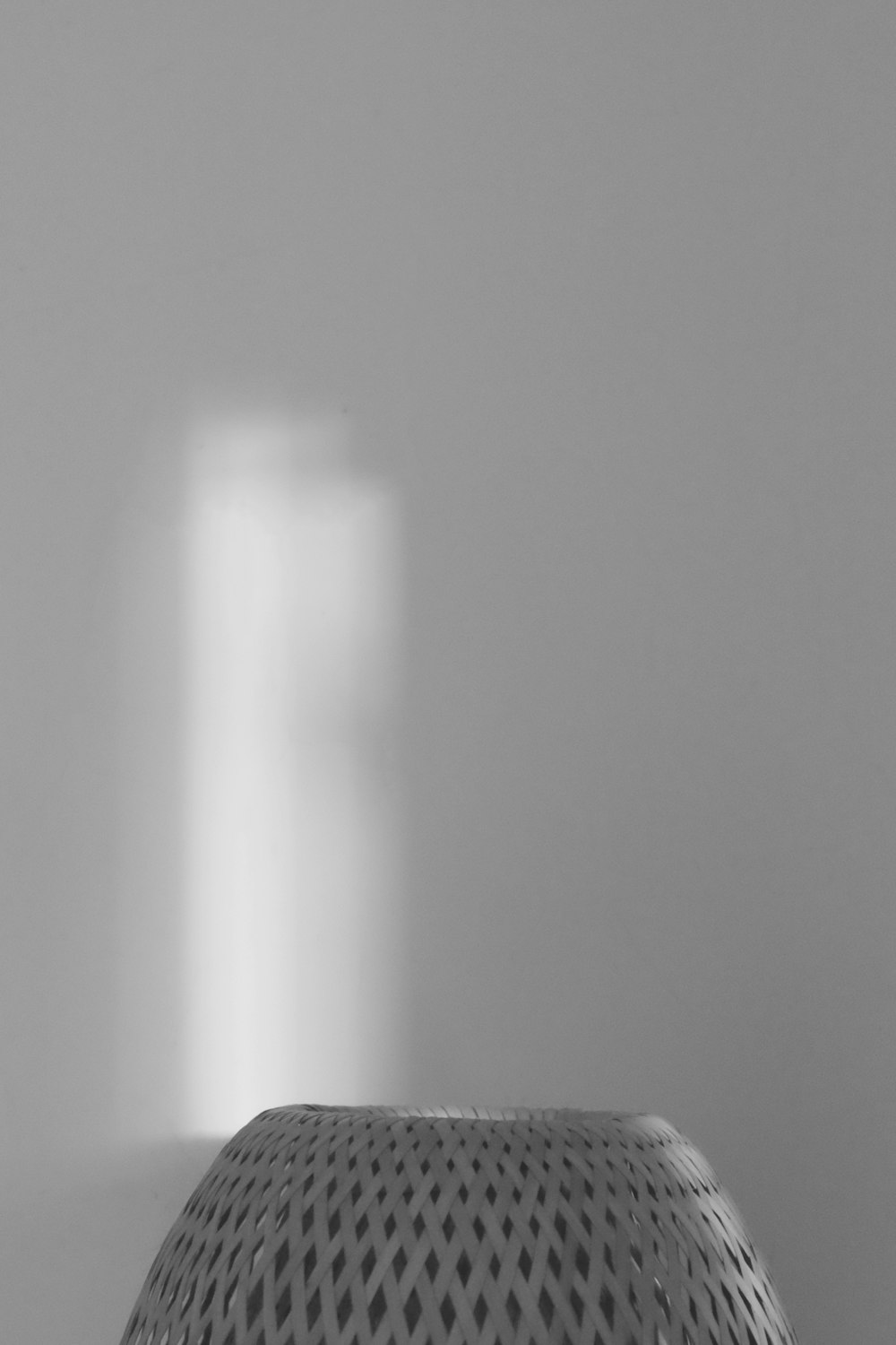 uma foto em preto e branco de uma luz entrando através de uma janela