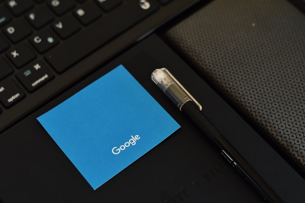 a pen sitting on top of a notebook next to a keyboard