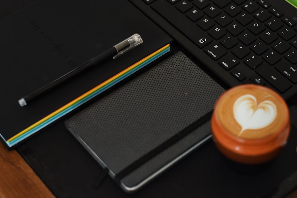 a cup of coffee sitting next to a laptop computer