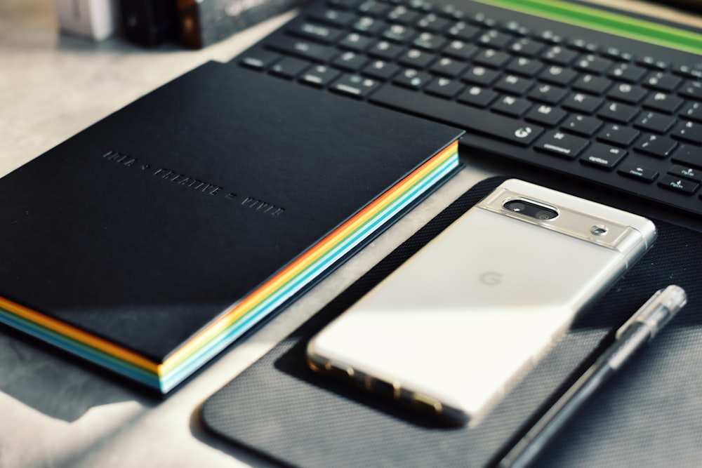 a notebook, pen, and cell phone on a table