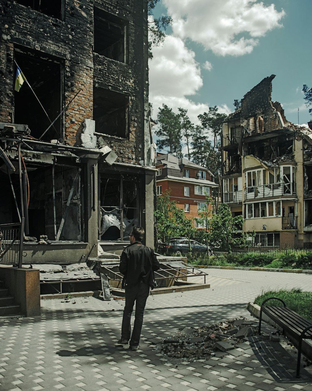 a man standing in front of a destroyed building