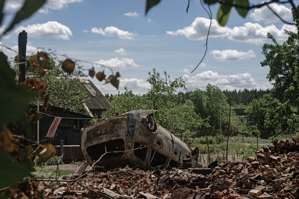 an old car is sitting in a pile of leaves