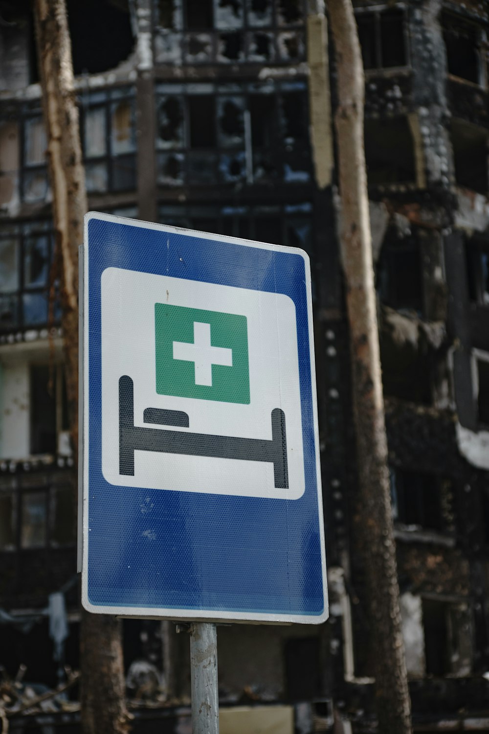 a blue and white sign with a green cross on it