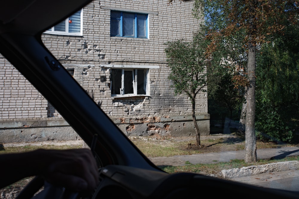 a person driving a car past a brick building