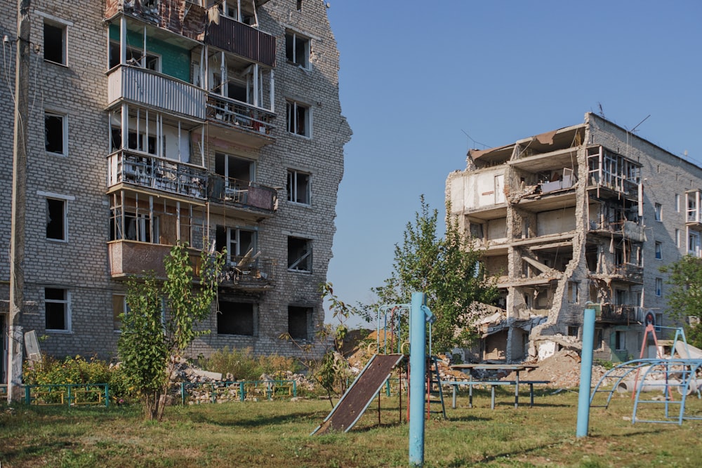 an abandoned building with a playground in front of it