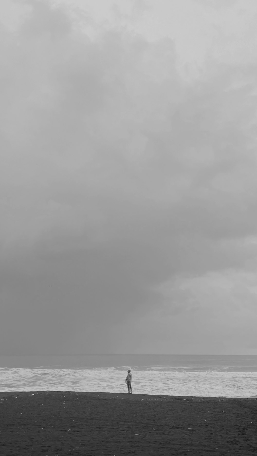 a person standing on a beach flying a kite