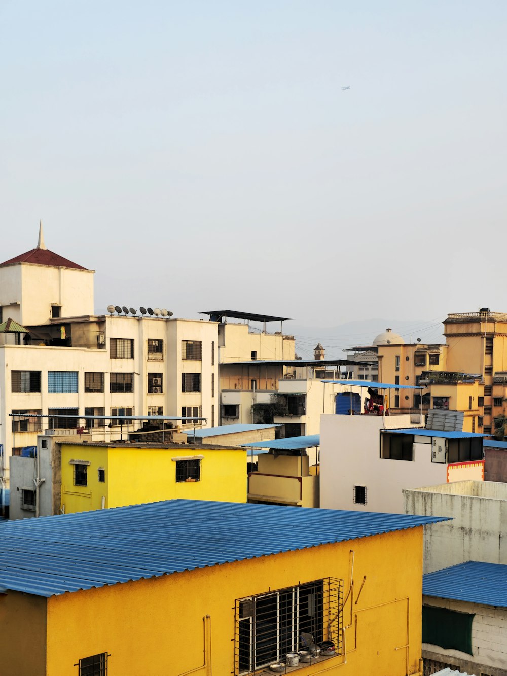 a yellow building with a blue roof in a city