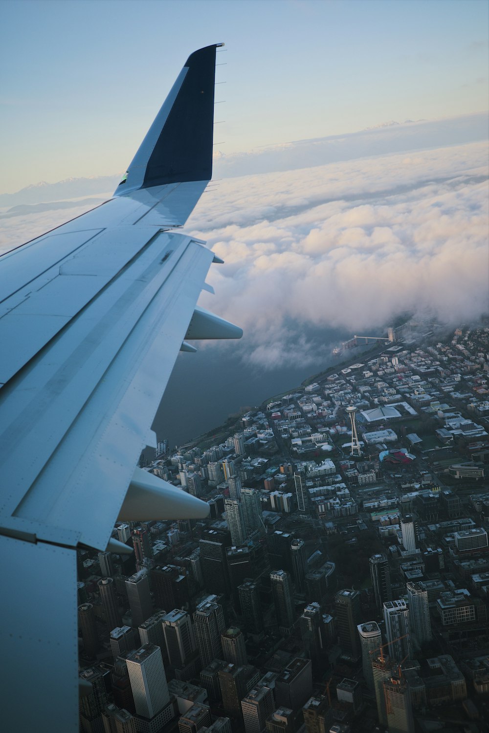 the wing of an airplane flying over a city