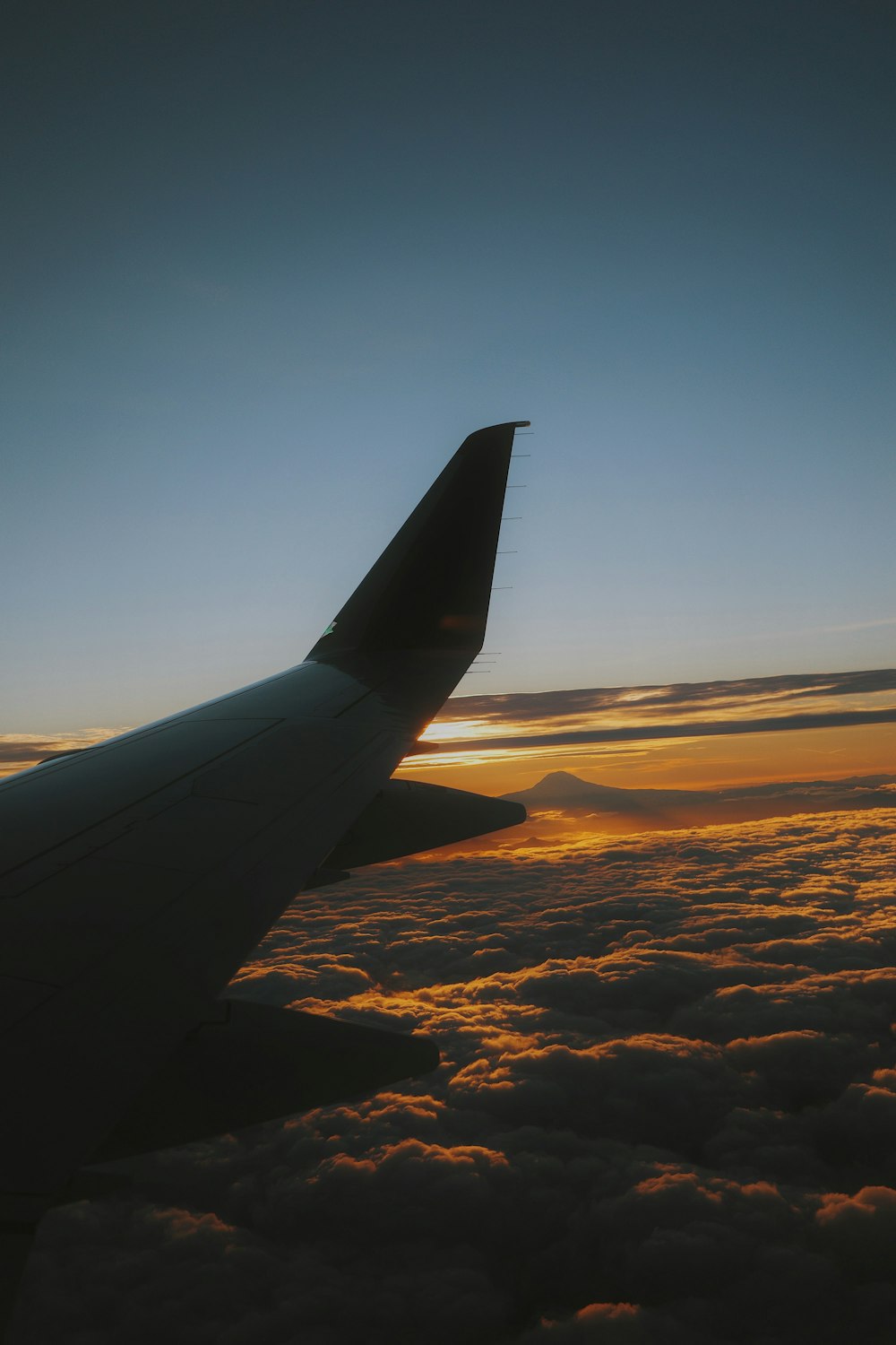 the wing of an airplane as the sun sets