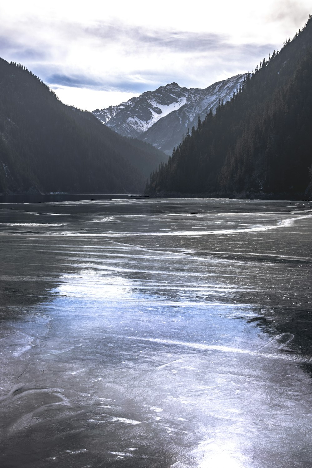 a frozen lake with mountains in the background