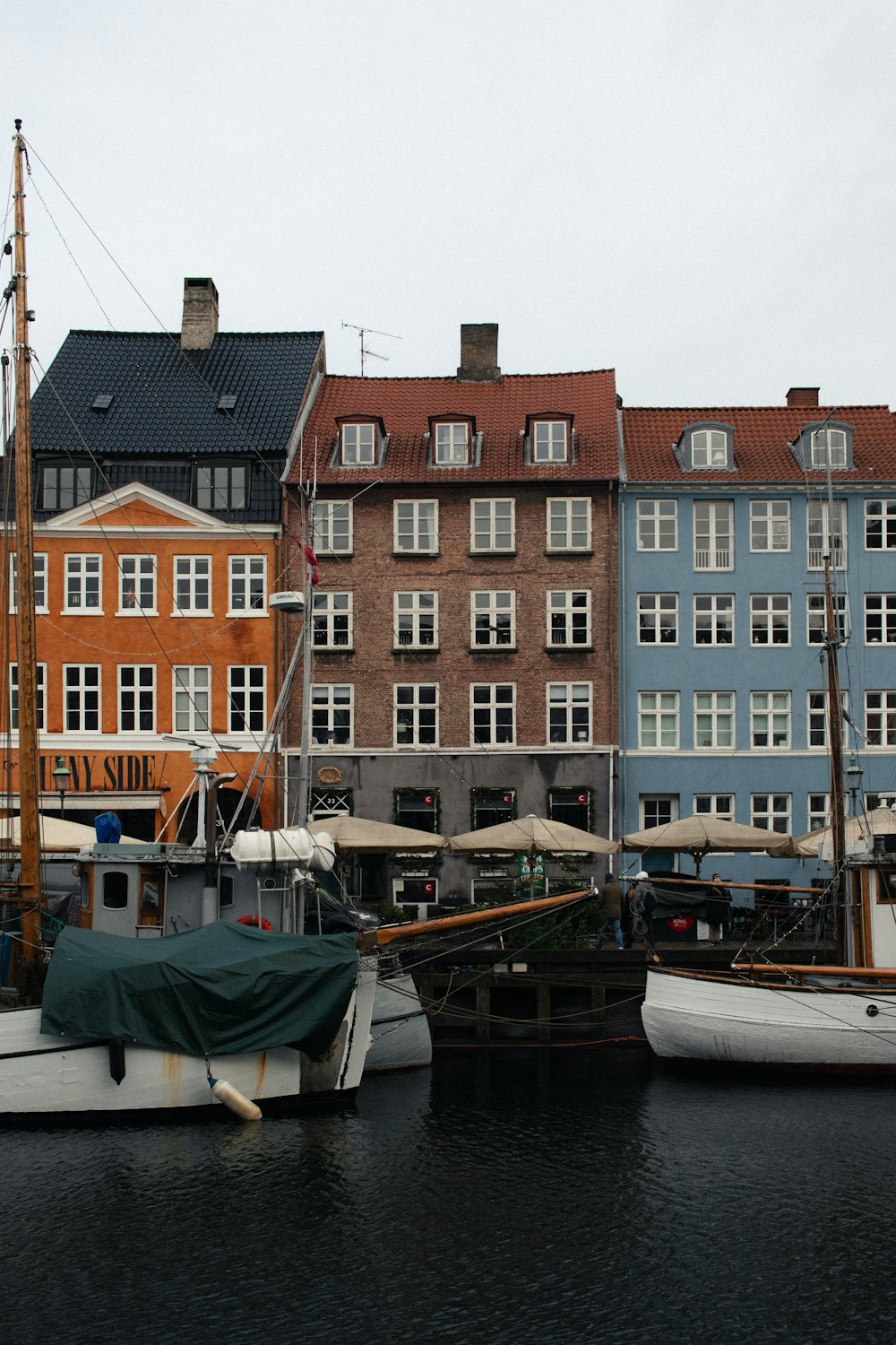 a group of boats sitting in a harbor next to tall buildings