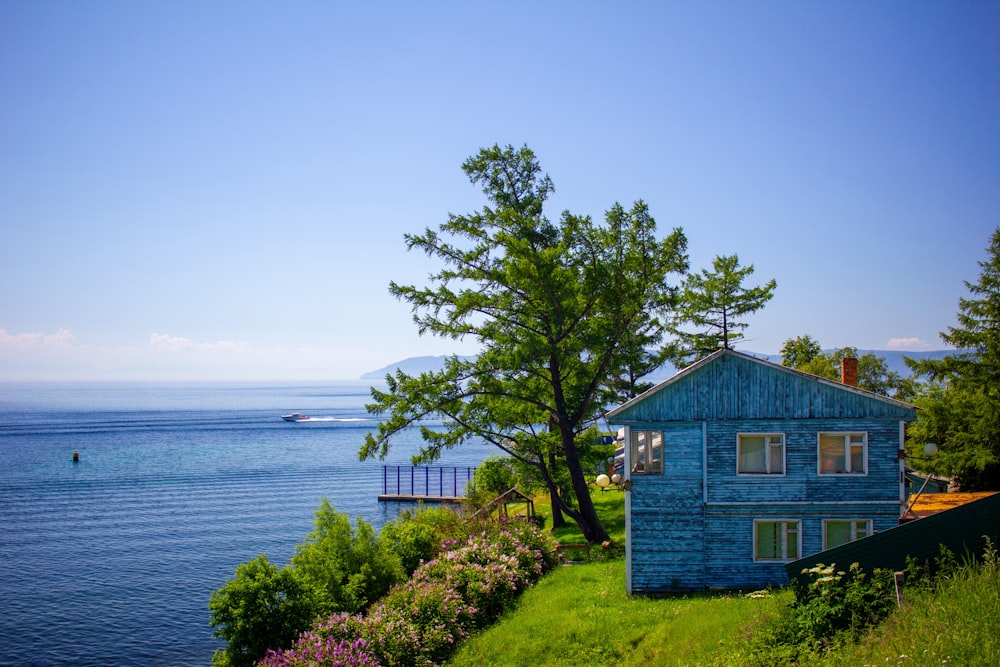 a blue house sitting on top of a lush green hillside