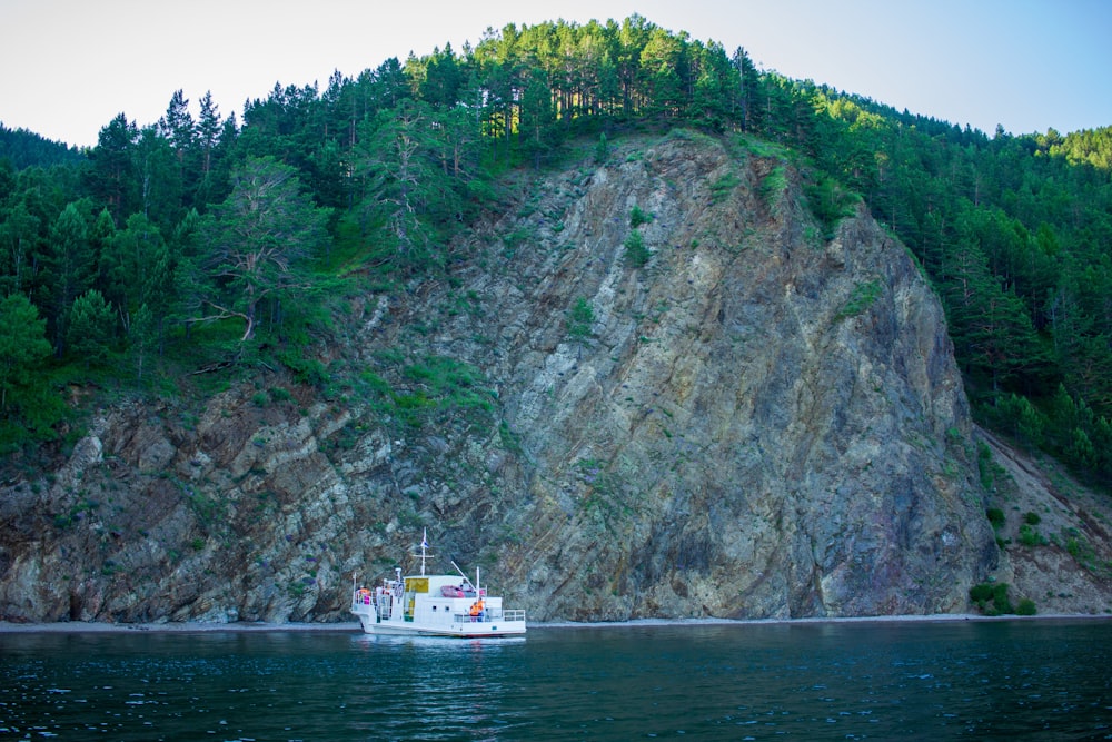 a boat on a body of water near a mountain