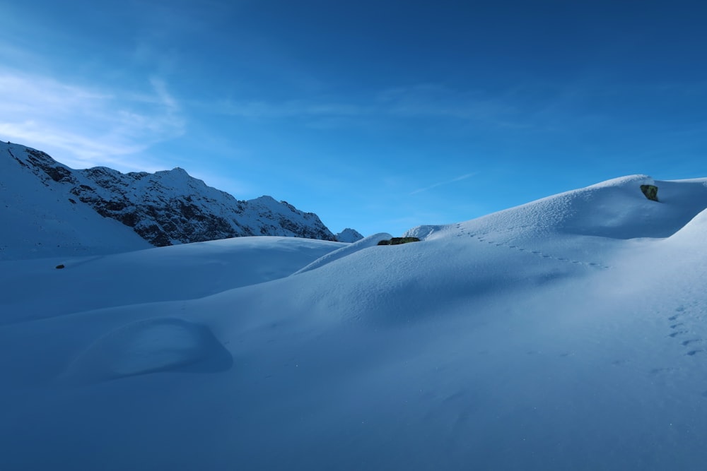 a person riding a snowboard down a snow covered slope