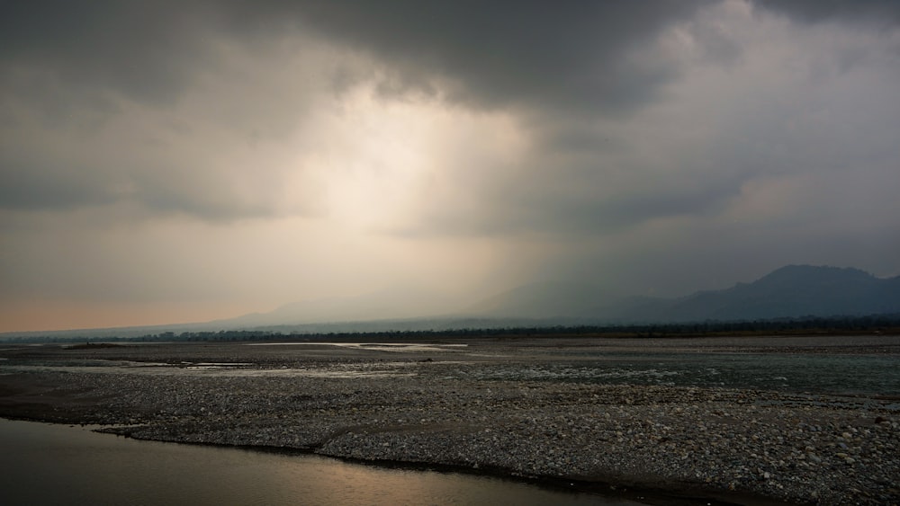 a large body of water under a cloudy sky