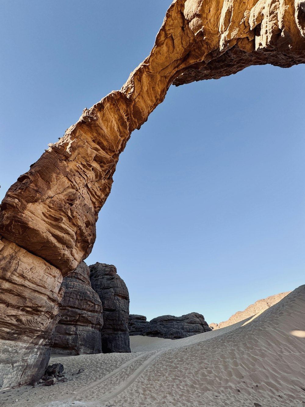 a large rock arch in the middle of a desert