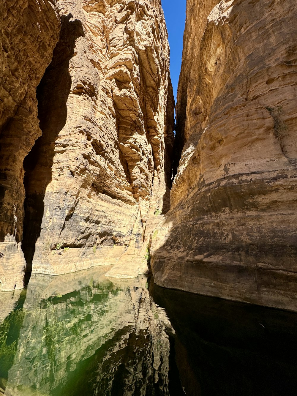 a narrow canyon with a body of water in the middle of it