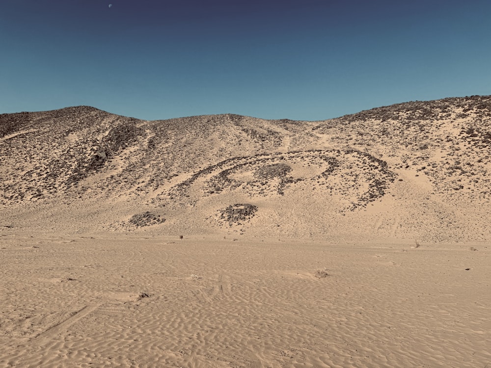 a desert landscape with a mountain in the background