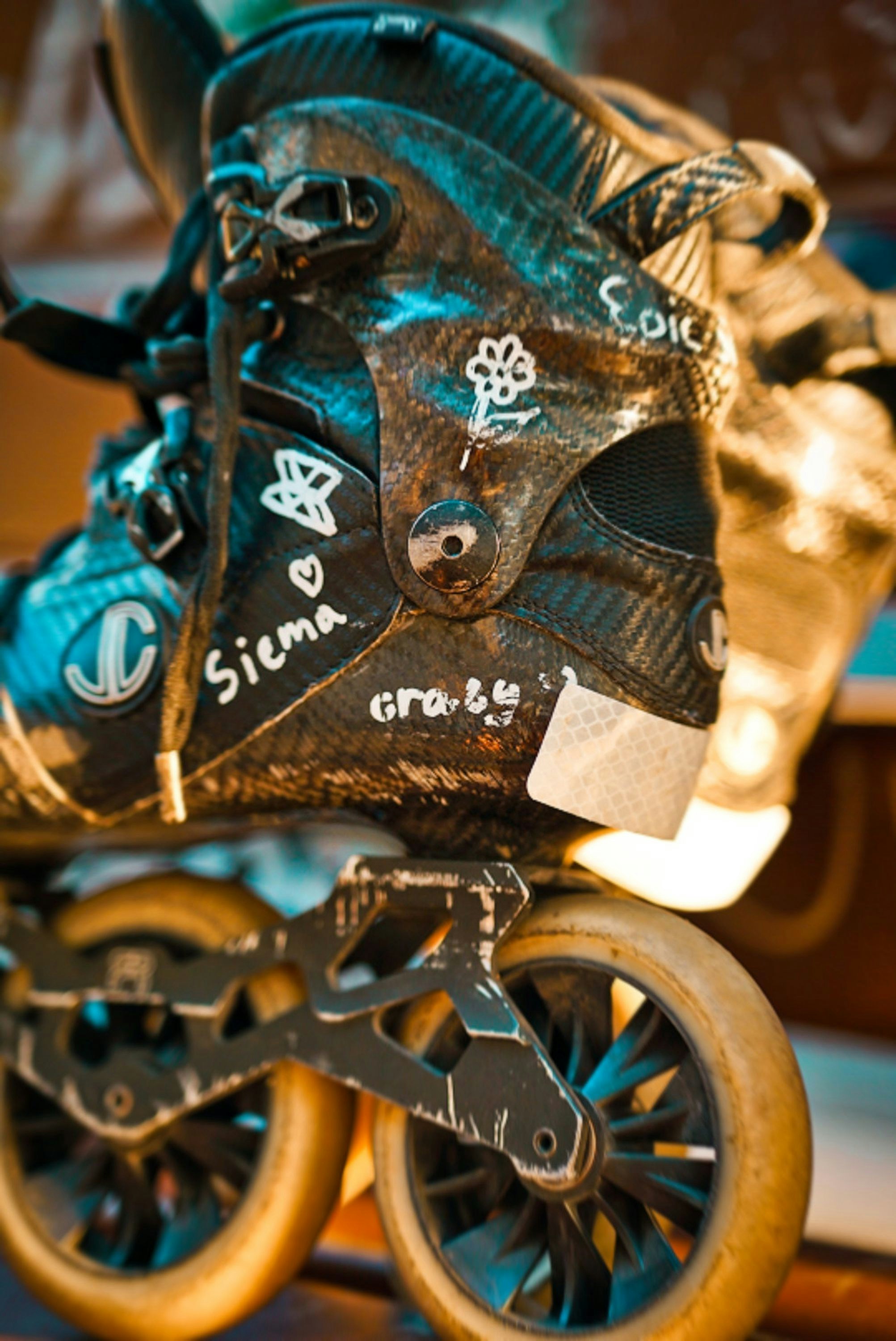 Worn inline skate boot with handwritten markings and light wheels.